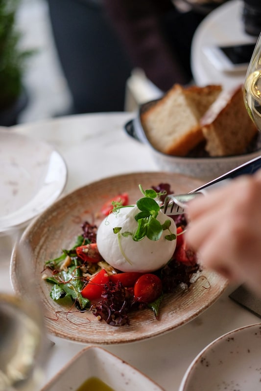 Salatschüssel mit Burrata da aufgeschnitten wird
